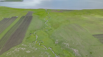 Wall Mural - A llittle creek flowing among green meadows in Ardahan city of Turkey.