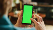© Gorodenkoff - Man Scrolling Feed and Double Tapping on Display on Smartphone with Green Screen Mock Up Display. Male Resting at Home, Checking Social Media on Mobile Device. Close Up Over the Shoulder Photo.