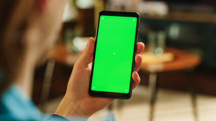 Poster - Man Swiping on Display and Scrolling Feed on Smartphone with Green Screen Mock Up Display. Male Resting at Home, Checking Social Media on Mobile Device. Close Up Over the Shoulder Photo.