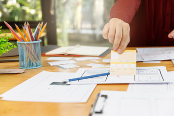 UX UI Concept, Graphic designers work together with UX UI designer planning application template layout framework for mobile phone computer mobile