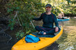 © Sergey - Senior man. A trip on a SAP board. A narrow river in the middle of the forest, an extreme route. bag with water protection. Tours and tourism, active recreation.