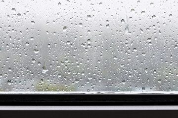 Canvas Print - raindrops and trickles of rain close up on window in heavy rain