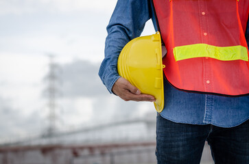 Yellow helmet hard hat safety in the hands of construction engineer.