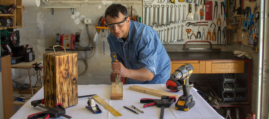 Sticker - Image of a handyman who carves wood with a hammer and chisel. Do-it-yourself and bricolage works