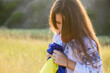 © o_lypa - A sad teenage girl holds a Ukrainian flag to her chest.