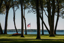 Old Glory Waves Through The Trees And Over A Sky Blue Lake