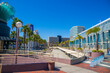 a gorgeous summer landscape at the Long Beach Convention Center with tall lush green palm trees and skyscrapers and office buildings in the skyline with blue sky in Long Beach California USA