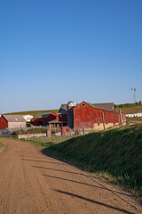 Wall Mural - Red barn and silo on an Amish farm beside a dirt road under a blue sky | Holmes County, Ohio