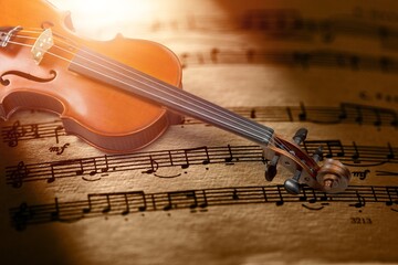 Wall Mural - The fretboard of an old vintage acoustic violin with strings next to sheets of music. A musical instrument.