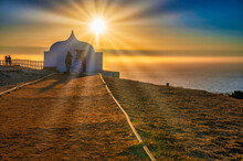 Sunrise Over The Ocean With A Small Chapel