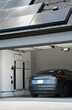 © coreyfrey - Solar Panels on a Roof Charging an Electric Vehicle and Home Battery Backup System in a Garage