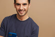 © SHOTPRIME STUDIO - Cheerful man with a phone in hand in a gray T-shirt beige background