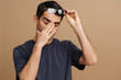 © SHOTPRIME STUDIO - portrait man gray t-shirt glasses cropped view emotions beige background