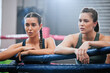 Active, fit and tired boxing female athletes and friends breathing, resting and taking a break after routine workout at the gym. Sporty, sweaty and dedicated women resting after exercise and cardio