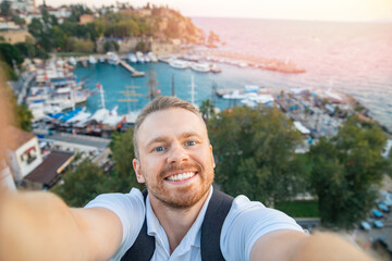 Wall Mural - Man tourist take selfie photo background Kaleici Antalya old town port, Mediterranean Sea, Turkey sunlight