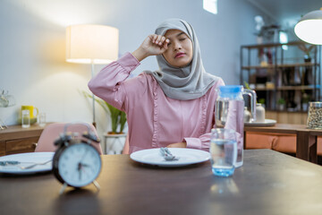 tired muslim woman wake up early to have a morning breakfast on fasting month. sahur concept in ramadan