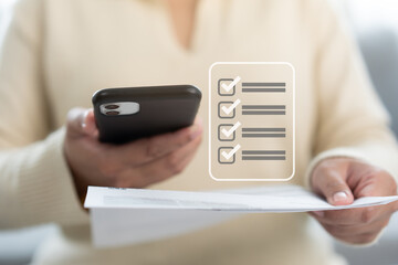 Woman holding paper bill invoice and mobile phone