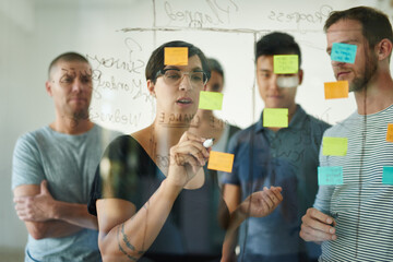 Aufkleber - Designers planning a strategy for a group project on a glass whiteboard together in a meeting. Creative, confident and professional young men and women writing smart ideas down together as a team