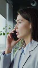 businesswoman with a serious look talking on a mobile phone in the office
