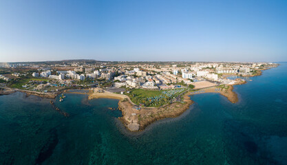 Wall Mural - Aerial bird's eye view Pernera beach Protaras, Paralimni, Famagusta, Cyprus. The tourist attraction golden sand bay with sunbeds, water sports, hotels, restaurants, people swimming in sea from above. 