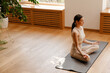 © Drobot Dean - Young white woman meditating on mat during yoga practice