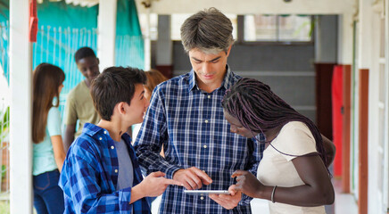 Sticker - Teacher in the school hallway discussing with his teenager multi ethnic classroom