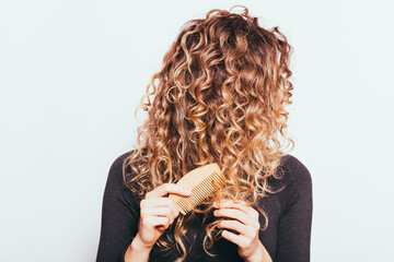 Wall Mural - Woman combing her naturally curly hair