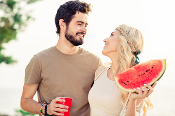 Sticker - Portrait of idyllic lovely partners drink beer eat watermelon communicate speak enjoy fresh air outside