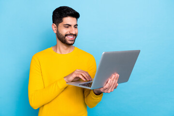 Wall Mural - Photo of positive cheerful man hands hold use wireless netbook isolated on blue color background