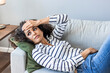 © Dragana Gordic - Frustrated young woman suffering from the headache while sitting on the sofa at home. Feeling bad. Upset depressed young woman lying on couch feeling strong headache migraine