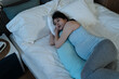 © PR Image Factory - view from above restless asian pregnant mom is looking into distance feeling depressed while lying on her side in bed alone with a maternity pillow at midnight
