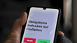 © maurice norbert - Un investisseur analyse un fonds etf obligations indexées sur l’inflation sur un graphique. Un téléphone affiche le cours de l'ETF. Texte en français francais Obligations indexées sur l’inflation