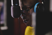 Crop Concentrated African American Female Singer In Eyeglasses And Headphones Near Microphone Recording Music In Studio