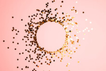 Round Frame From Golden Star Shaped Glitter Confetti On Pink Background. Festive Flat Lay Holiday Pastel Backdrop With Copy Space.