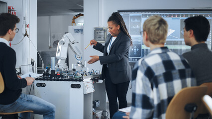 black teacher and diverse group of young students brainstorming at university robotics class. people