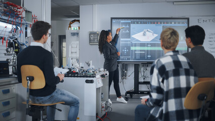 Teacher is Explaining Principles of Working With Robotic Hand, Showing Examples on Big Screen at Modern University. Teenagers Brainstorming and Asking Questions. Robotic Engineering Concept.