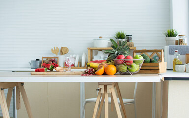 Nobody backgrond fruits, pineapple, banana, pomegranate, red and green apples for good health decorated on wooden table in cozy white clean kitchen with copy space. Healthy food and interior Concept.