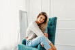 © ZaStock - Portrait of pretty blonde woman sits on a chair. Studio shot