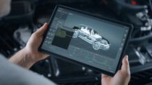 A car repairman performs wireless diagnostics of a car, scanning for errors and searching for breakdowns using a digital tablet on which a three dimensional model of the engine and problems.