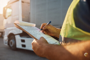 Wall Mural - Close up of trucking dispatcher going through checklist on parking lot.