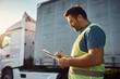 © Drazen - Cargo transportation manager taking notes while going through checklist on parking lot.