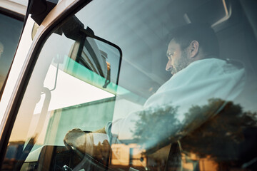 Wall Mural - Mid adult man driving truck on the road.