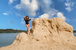 Attraktive Frau posiert im Badeanzug am Sandstrand am See