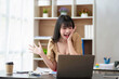© amnaj - Cheerful and beautiful Asian businesswoman is very excited and delighted because she is satisfied with the work she has accomplished achieve your goals with your laptop computer.