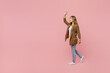 Full body young happy fun successful employee business woman 30s she in casual brown classic jacket walking going strolling waving hand isolated on plain pastel light pink background studio portrait