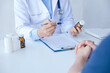 © aksonsat - Close up of doctor's hands is explaining and advising about using pills and treatment to patient.