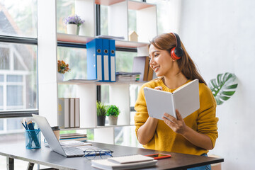 Young Asian university female wearing headphone listen to digital online course  reskill upskill school class development program in laptop computer.