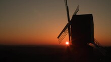 Sun Setting On The Horizon Behind A Traditional Wooden Windmill At Sunset 