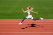 © Yevhen - Woman running during. Sport backgrounds. Runner. Professional sportswoman during running training session. Woman running jump on stadium track. Sportswoman in sportswear jumping