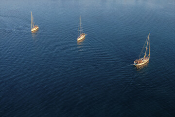 Wall Mural - Aerial drone view of sailing boats in the blue clear sea at sunset . Travel, vacation background. Peaceful seascape. Beautiful calming landscape